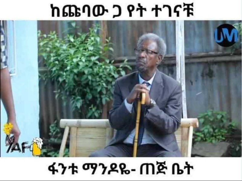 a man sitting on a chair with a cane in his hand